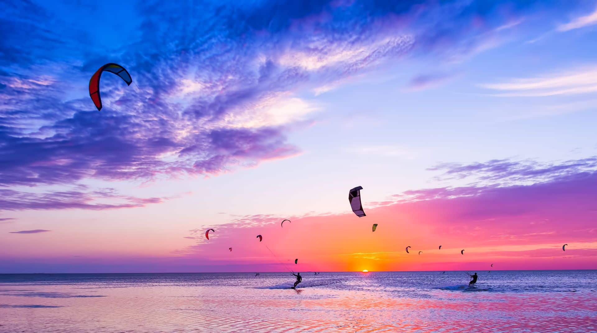 Kitesurfer bei Sonnenuntergang auf dem Meer