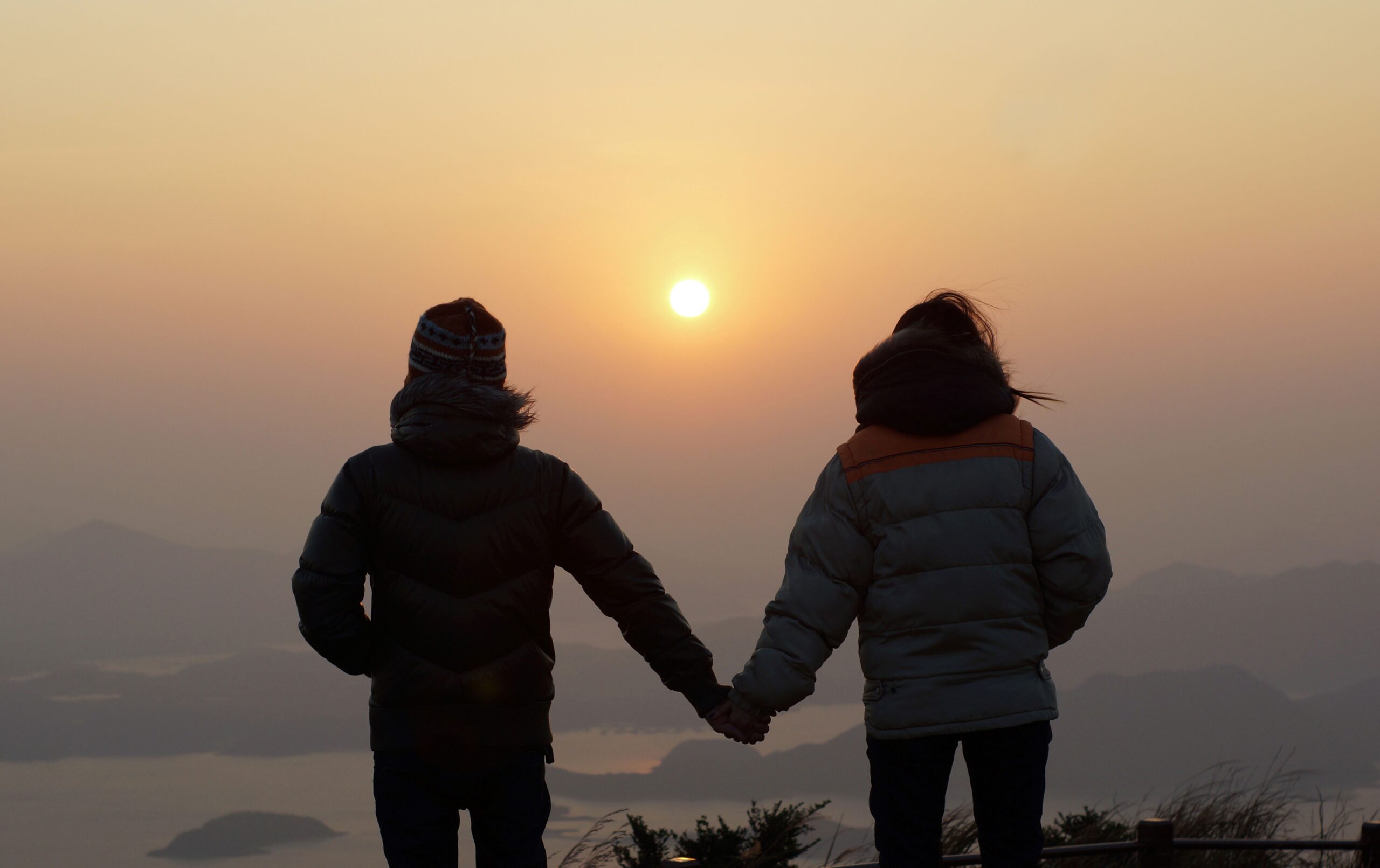 Paar hält sich bei Sonnenuntergang an den Händen