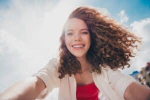 Frau mit lockigem Haar und Sonnenlicht | Clip In Extensions